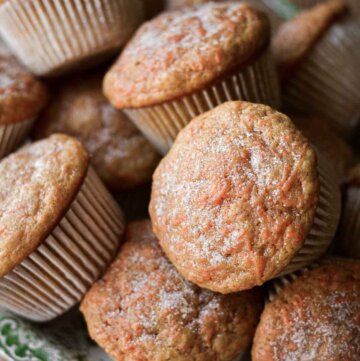 Carrot cake muffins piled on a plate.