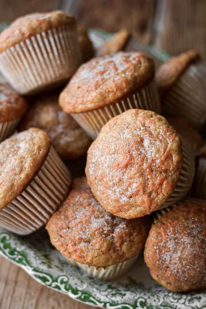 Carrot cake muffins piled on a plate.