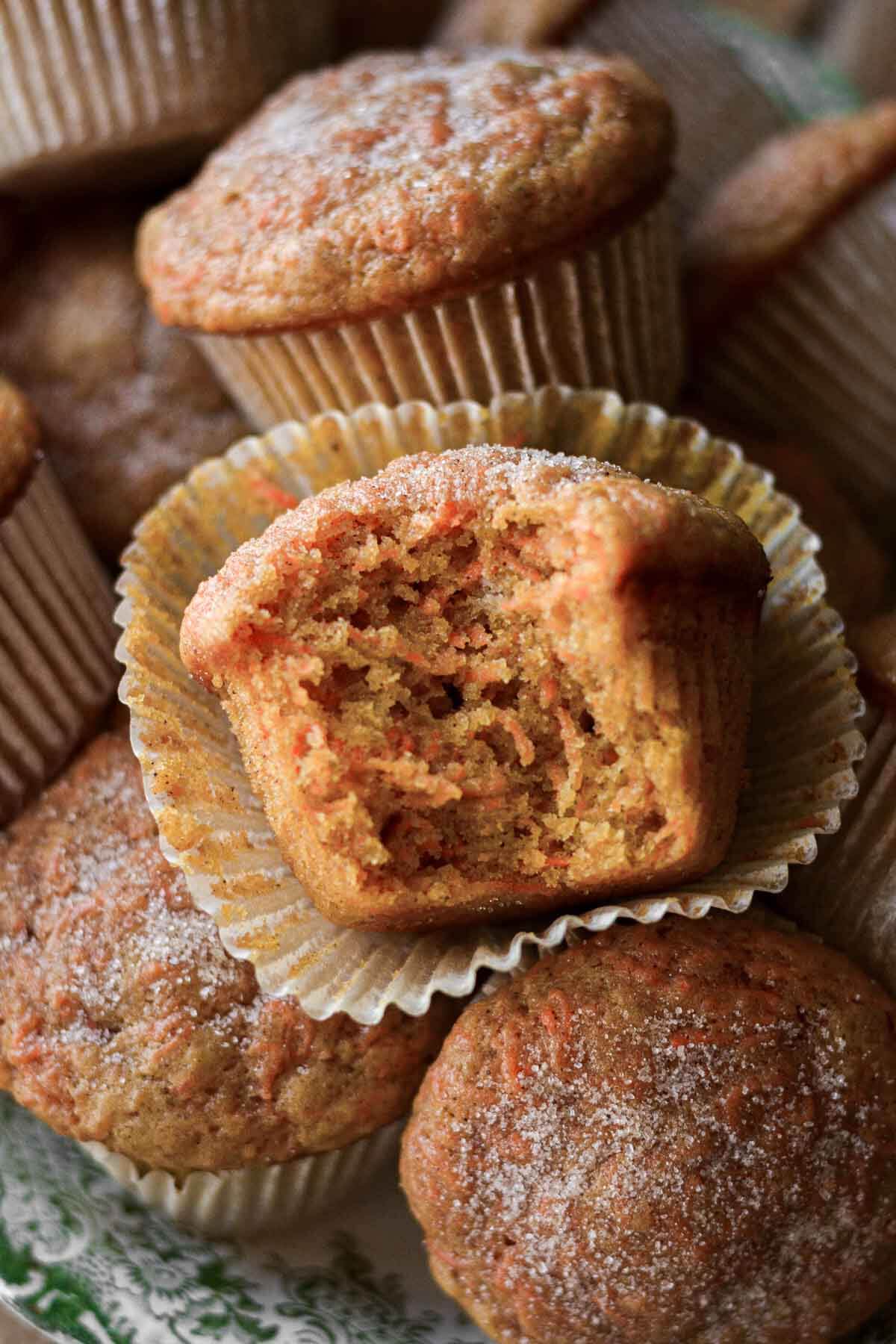 Carrot cake muffins, one with a bite taken.