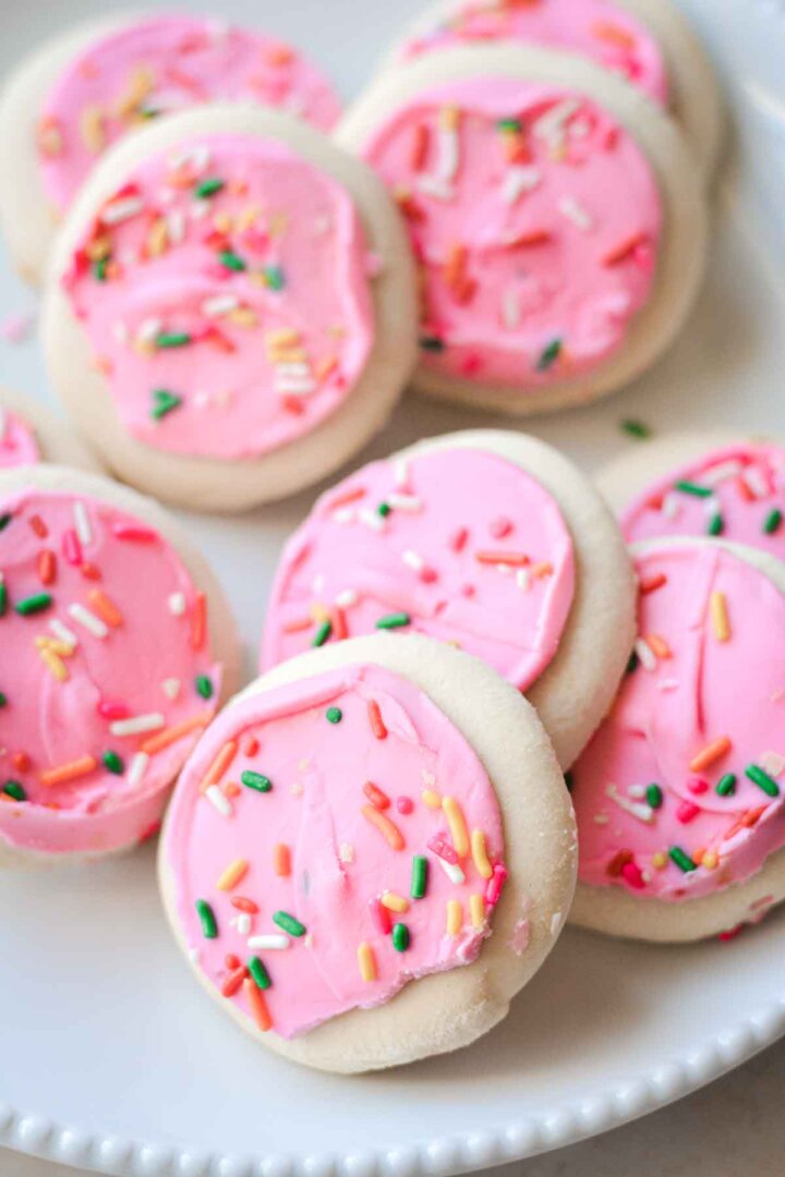 Bakery sugar cookies with pink frosting and sprinkles.