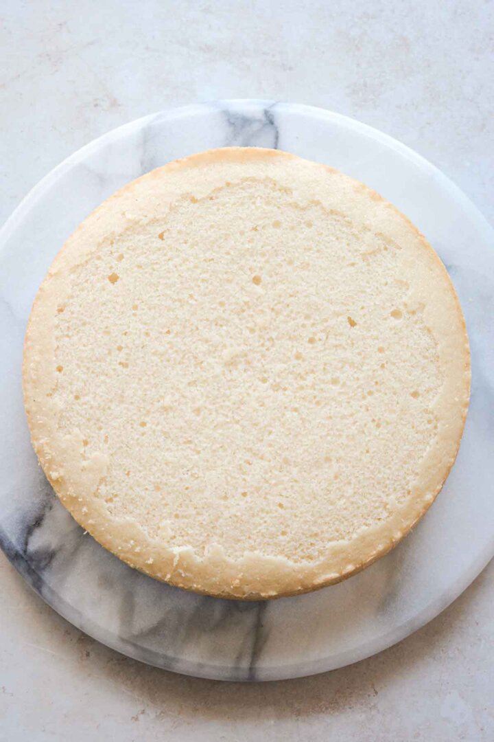 Step 1 for assembling a sugar cookie sprinkle cake - first layer of cake.