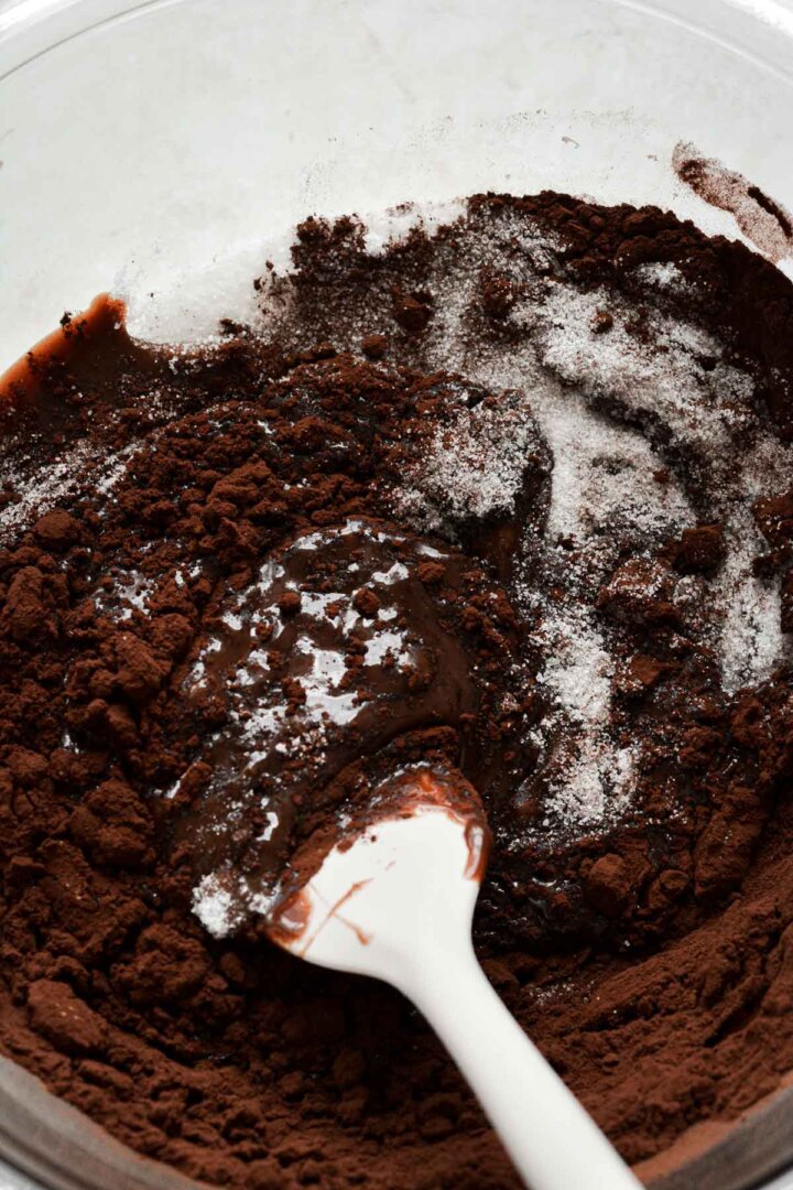 Step 4 for making brownie batter ice cream - stirring melted chocolate into sugar and cocoa powder.
