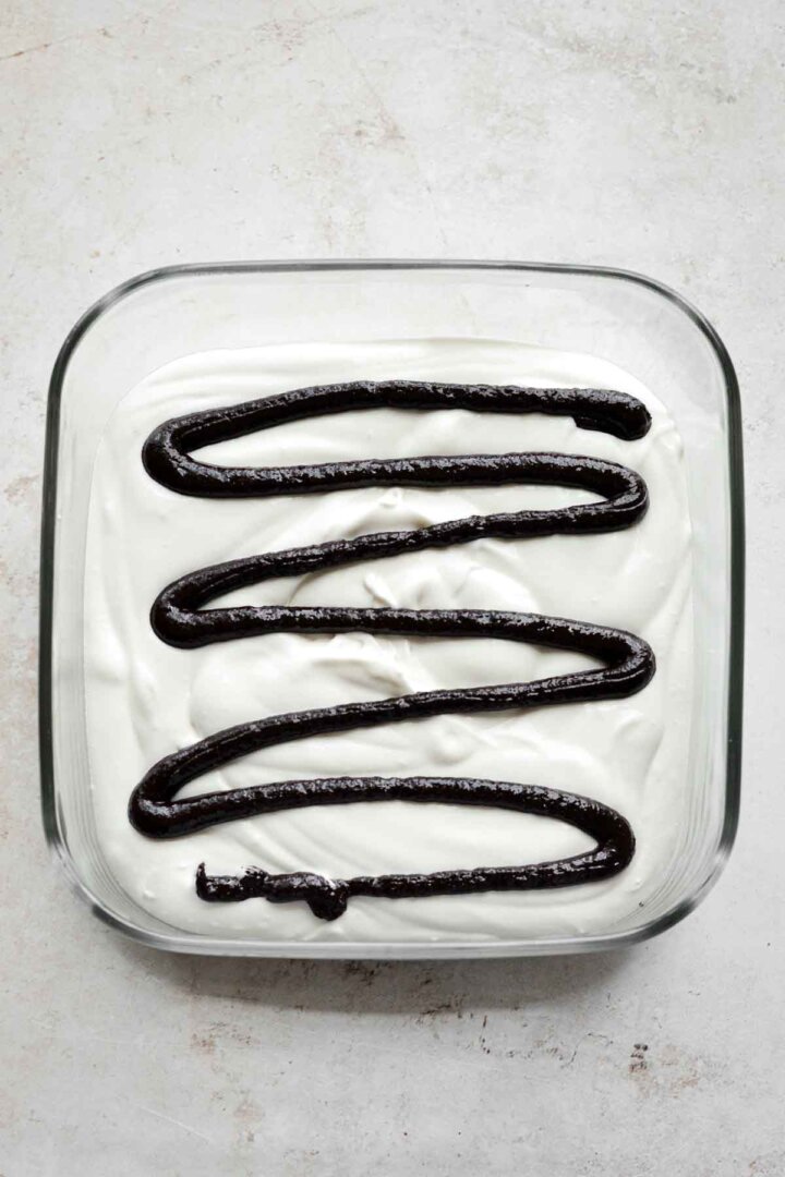 Step 7 for making brownie batter ice cream - brownie batter drizzled over ice cream.
