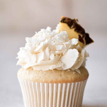 Pineapple coconut (pina colada) cupcake topped with a wedge of pineapple.