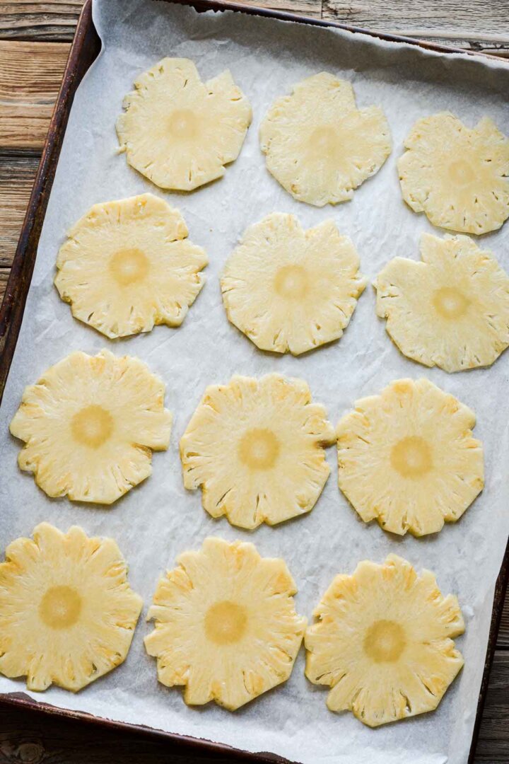 Pineapple slices on a baking sheet.
