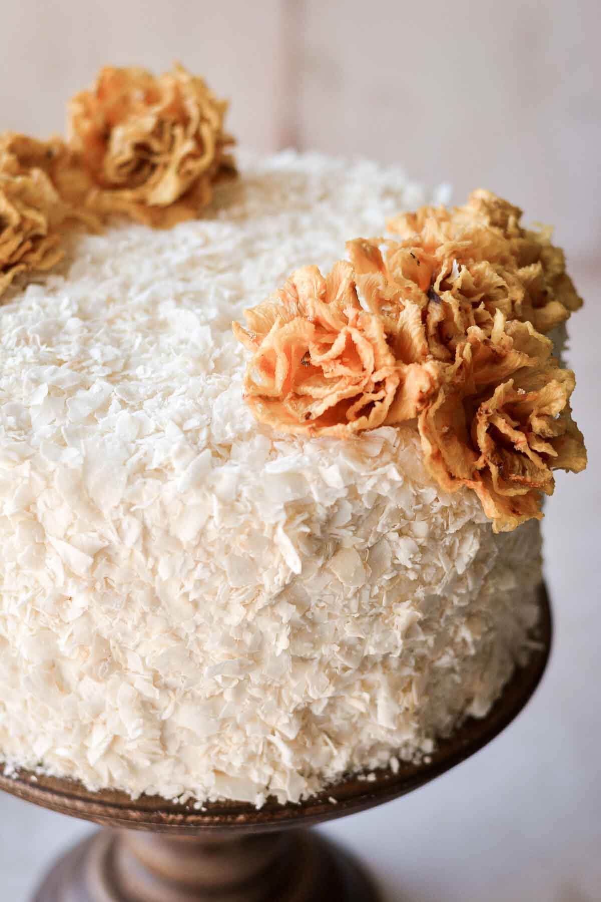 Pineapple coconut cake, decorated with dried edible pineapple flowers.