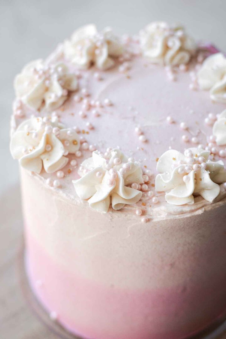 Pink ombre buttercream and sugar pearls on a layer cake.