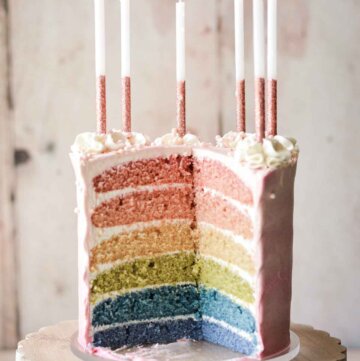 Six-layer rainbow cake, cut to show the layers inside.