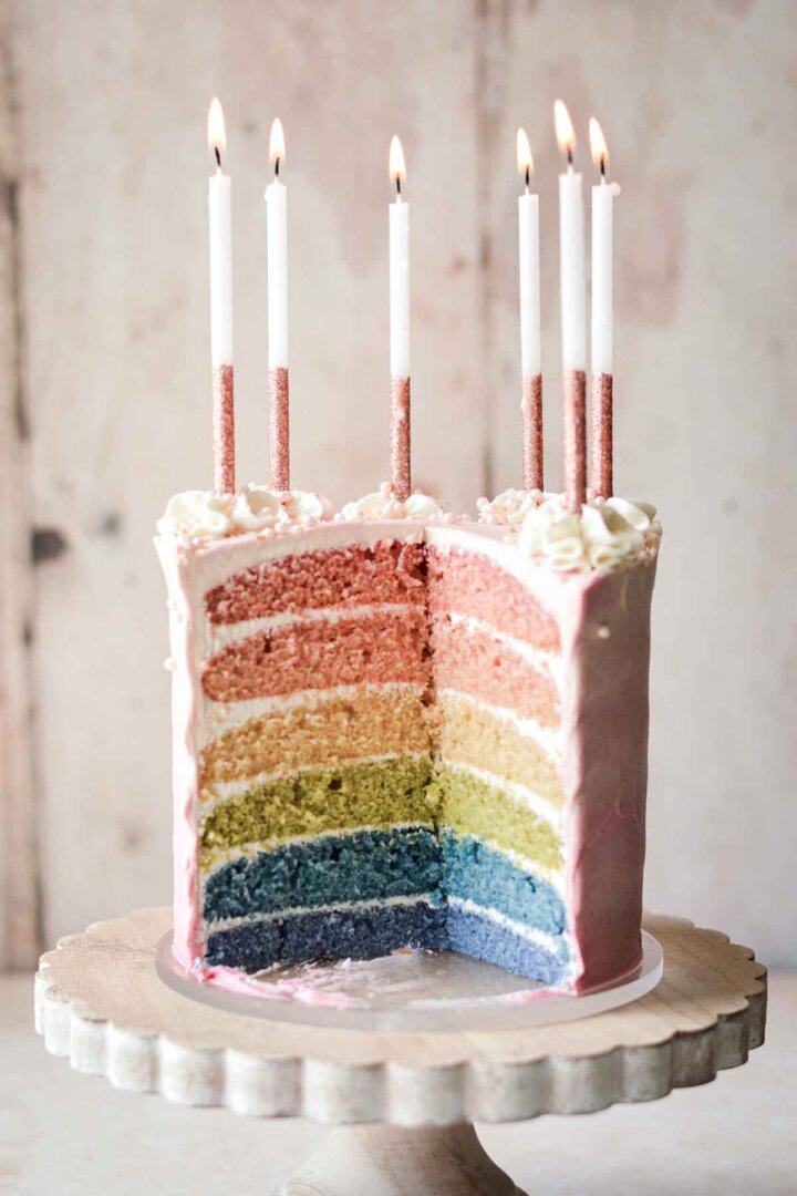 Six-layer rainbow cake, cut to show the layers inside.