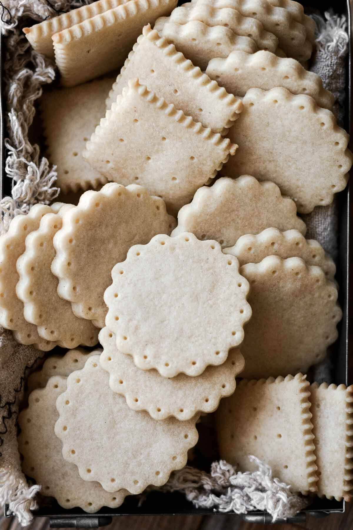 Vanilla shortbread cookies, cut in round and square shapes with fluted edges.