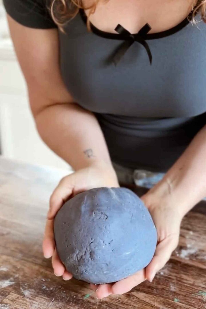 Holding cookie dough that's colored blue with butterfly pea flower powder.