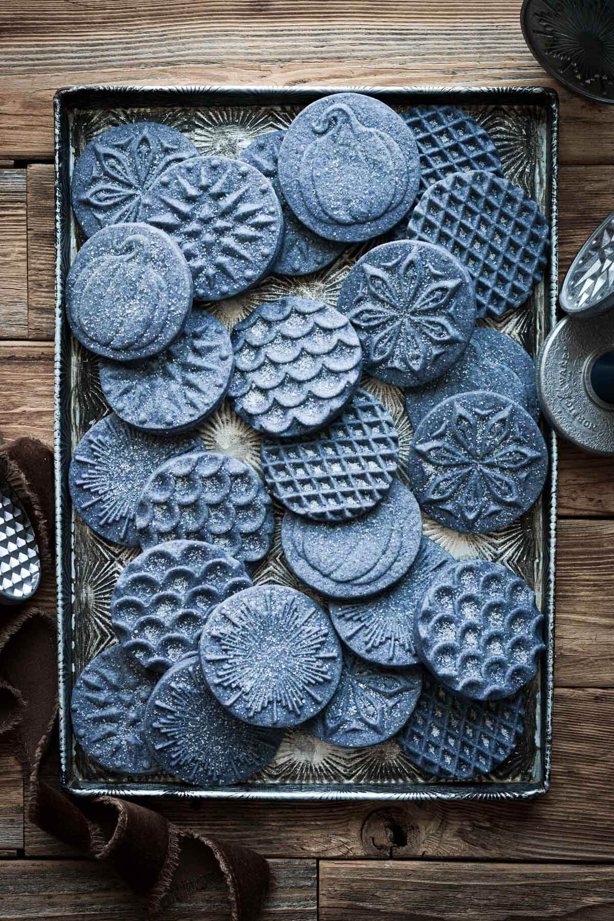 Stamped blue shortbread cookies on a vintage baking sheet.