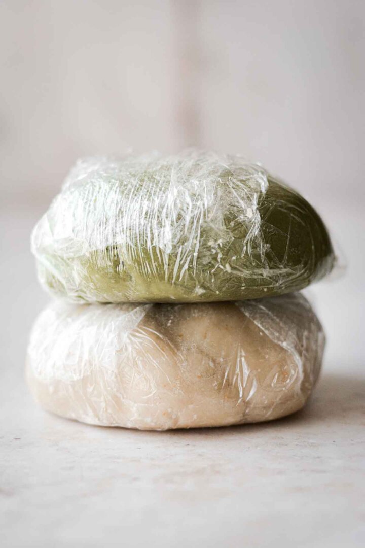 Green and white cookie dough, wrapped in plastic wrap.
