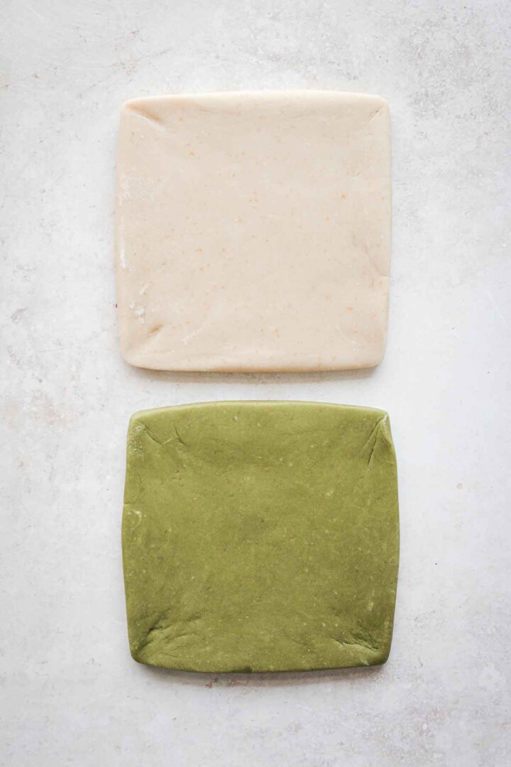 Green and white cookie dough, shaped into squares.
