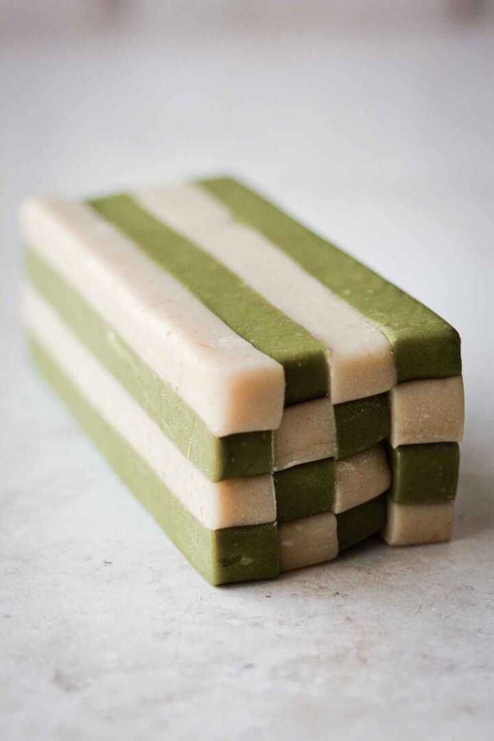 Step 5 for making green and white checkerboard cookies - stacking slabs of dough into a checkerboard pattern.