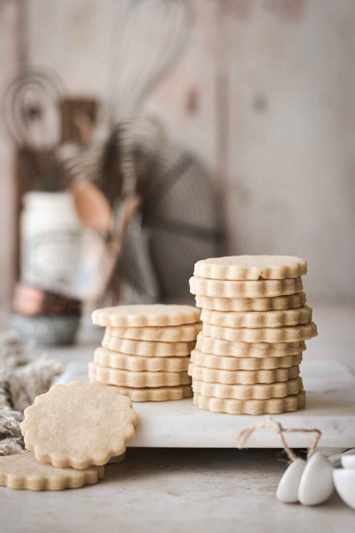 Stack of vanilla cutout cookies on a marble board.