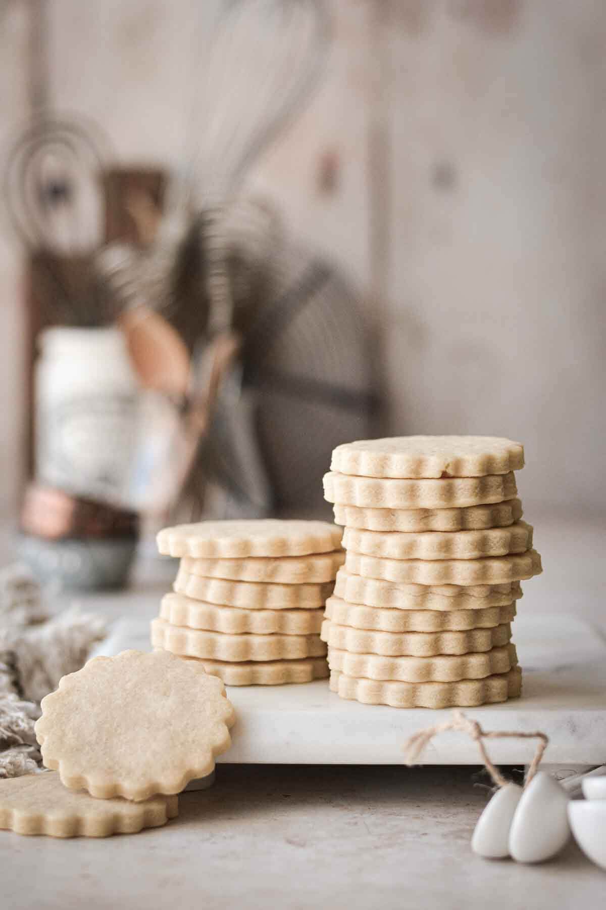 Stack of vanilla cutout cookies on a marble board.