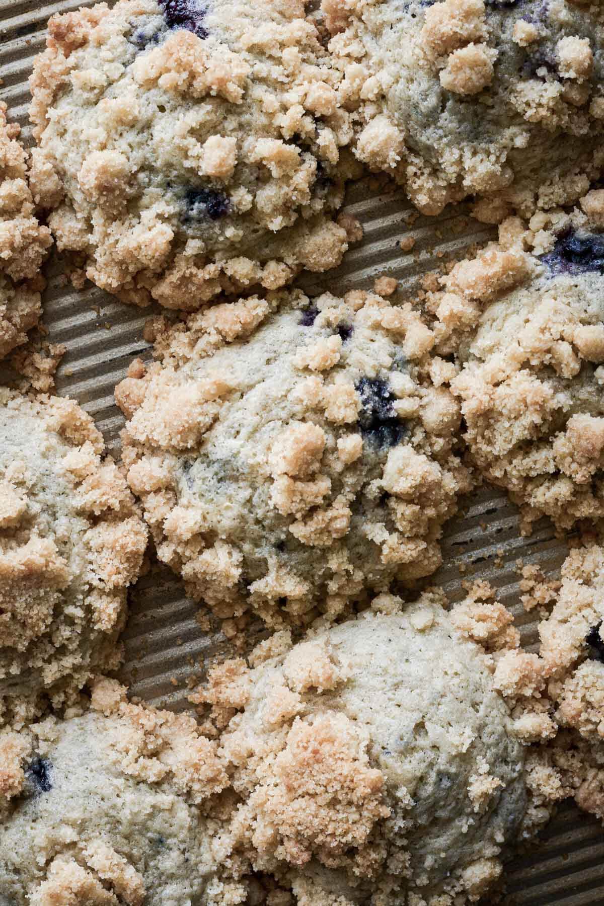 Blueberry crumb muffins in a muffin pan.