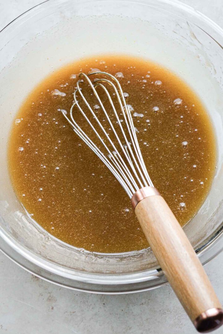 Step 2 for making butter pecan blondies - whisking butter, sugar and eggs.