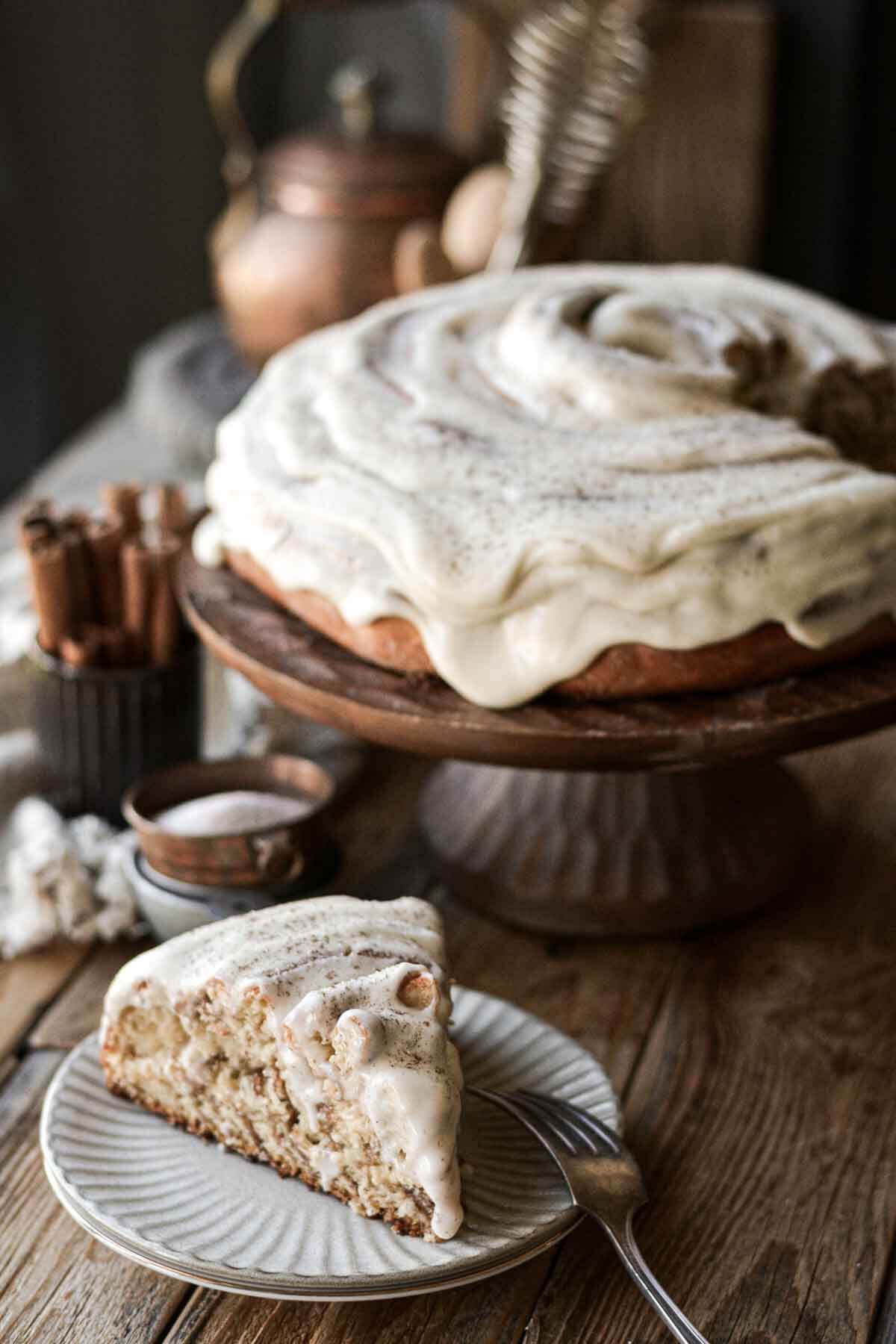 Cinnamon roll cake with one slice cut.