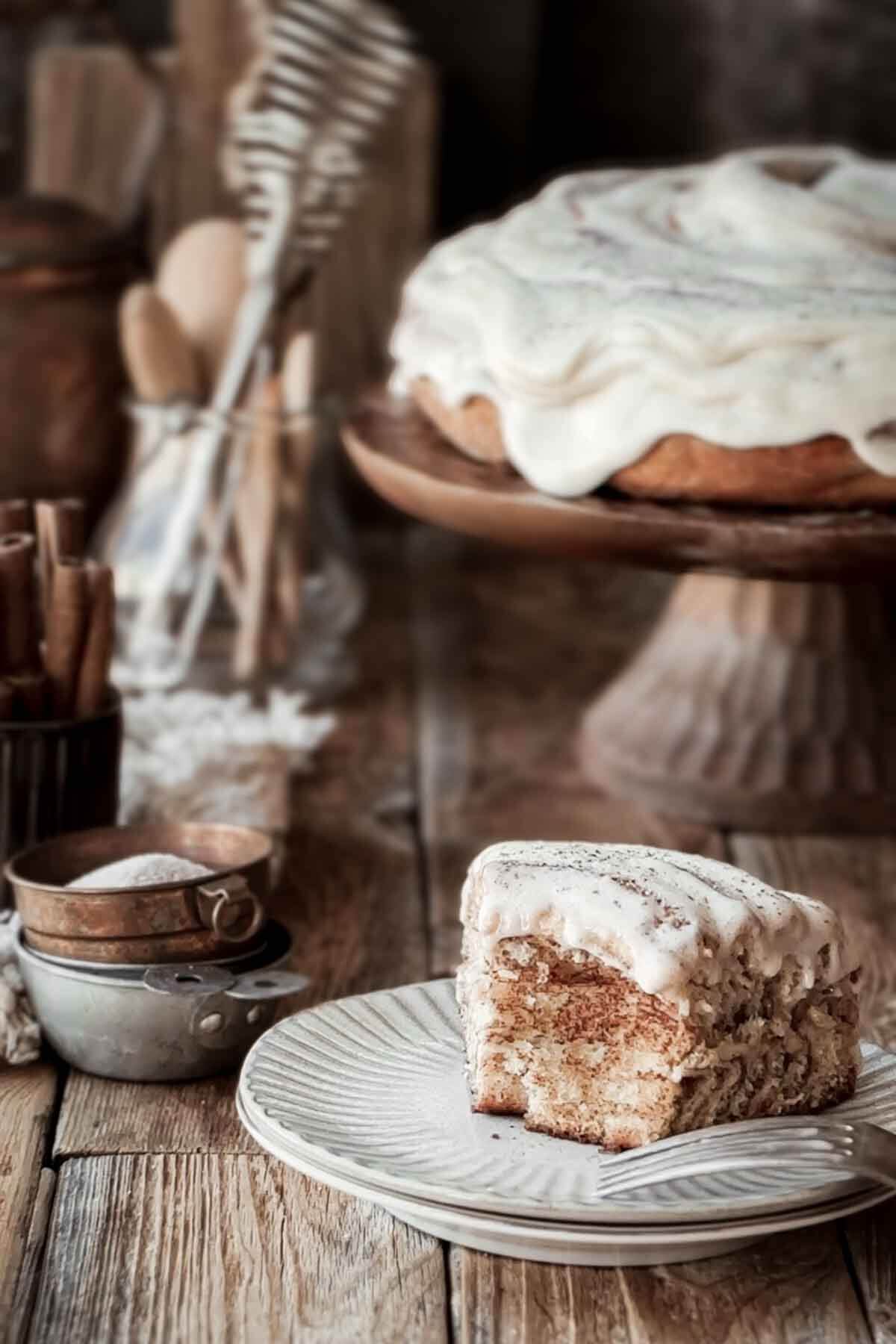 A piece of cinnamon roll cake with a bite taken.