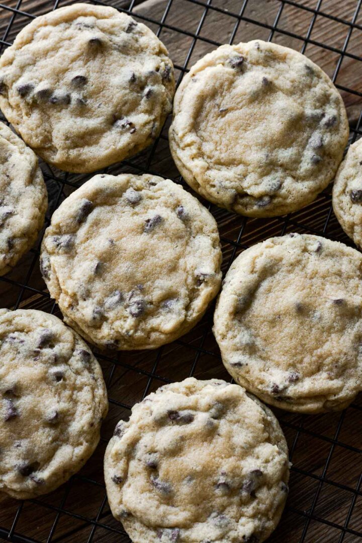Just baked chocolate chip cookies on a cooling rack.
