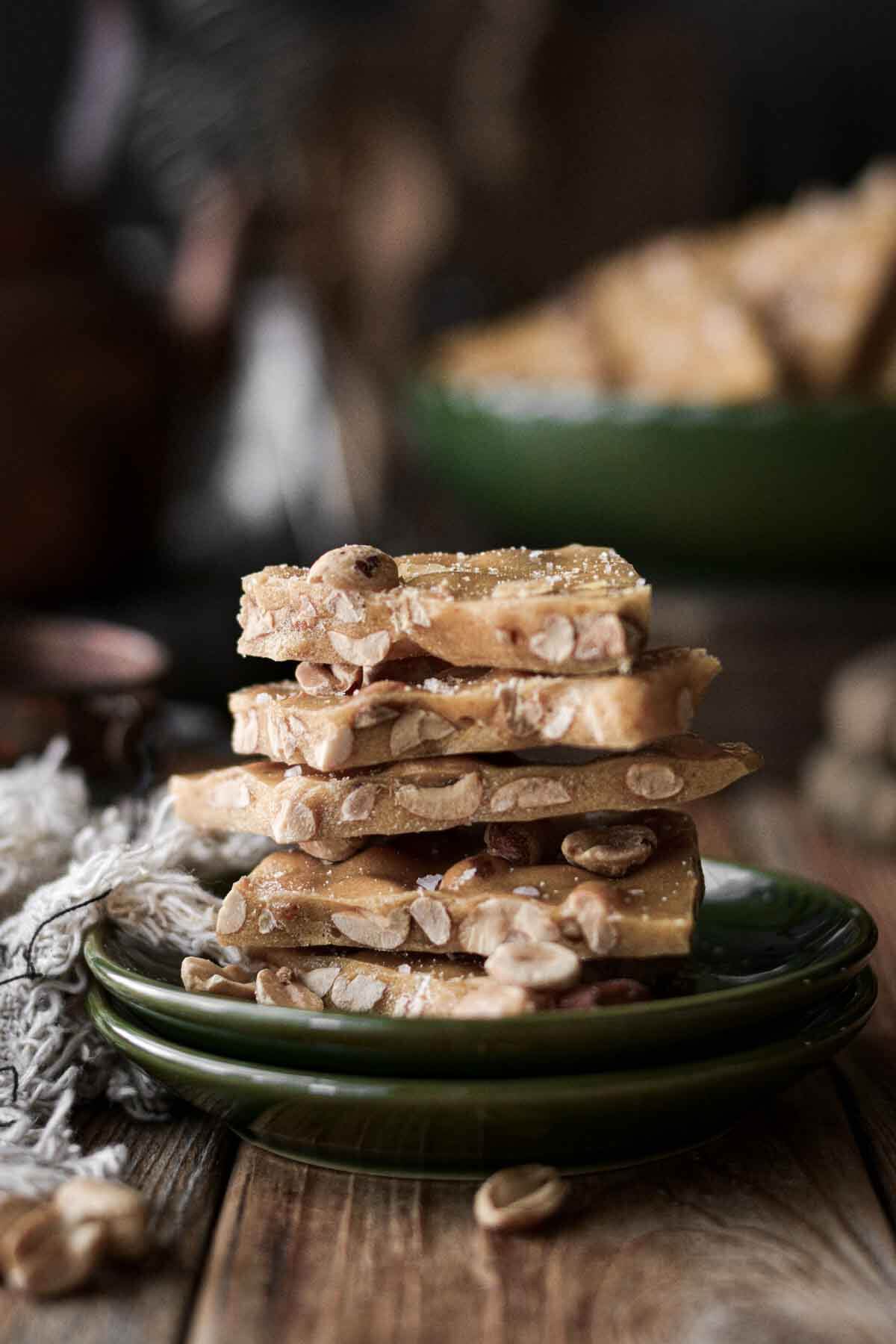 Peanut brittle, stacked on a plate.