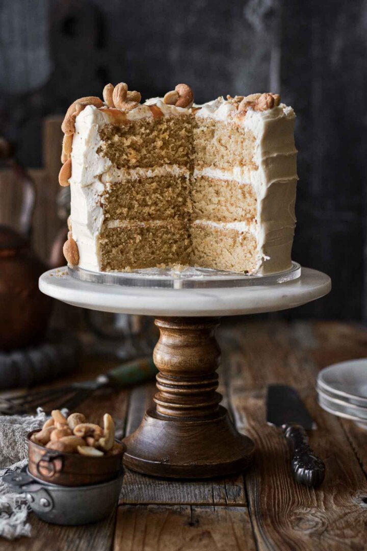 Cashew cake with caramel buttercream, sliced to show the layers inside.