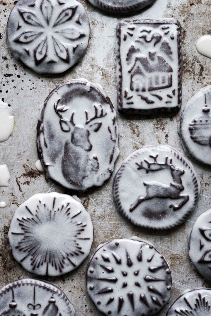 Iced chocolate Christmas cookies stamped with Christmas designs.