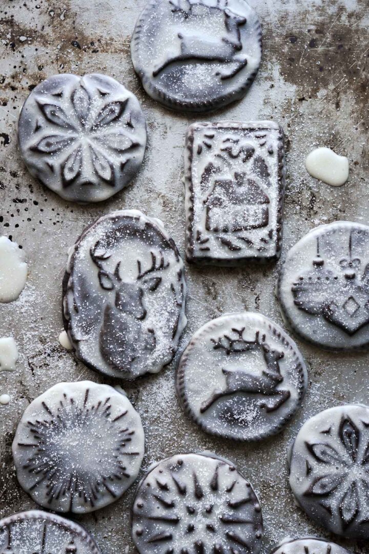 Iced stamped chocolate Christmas cookies sprinkled with sugar.